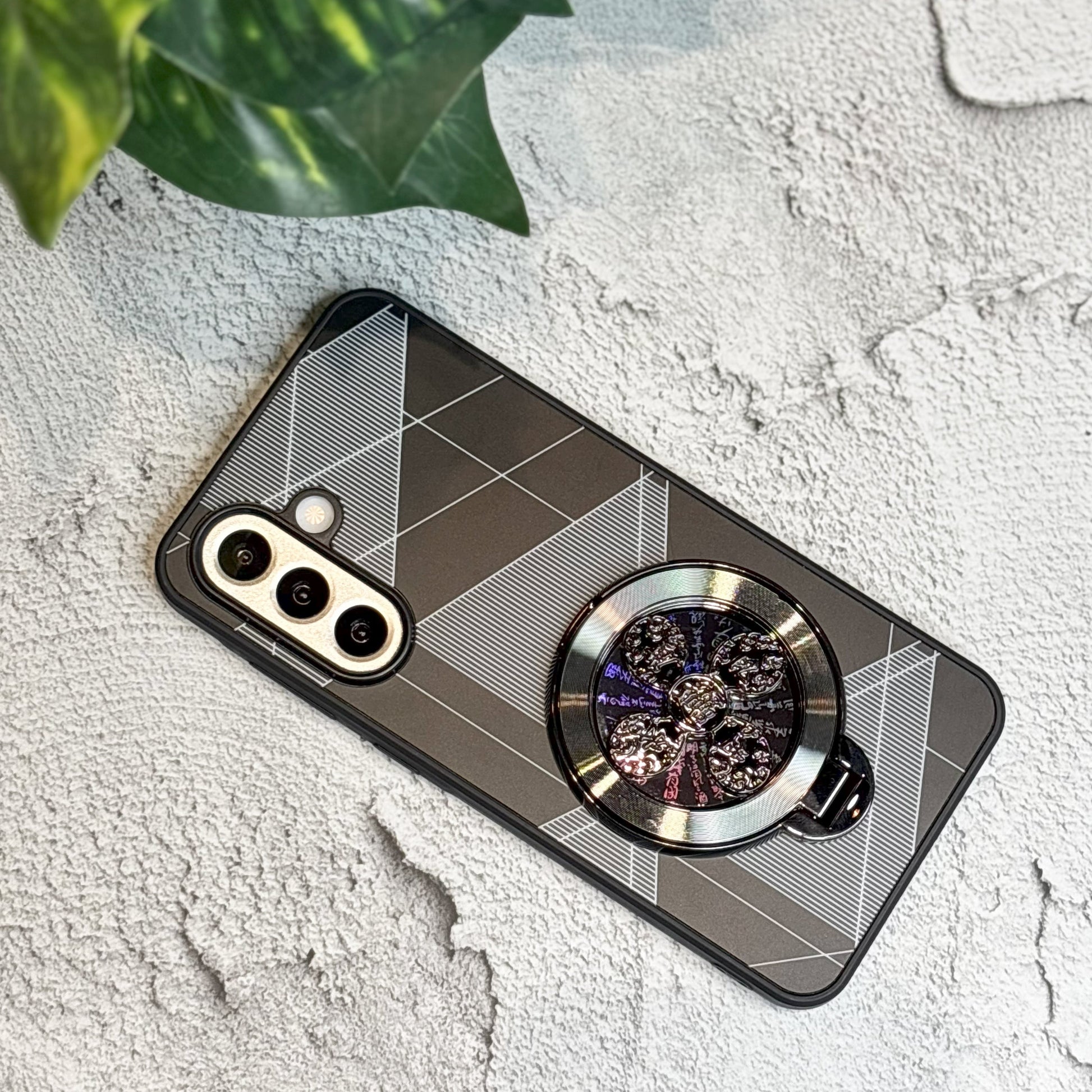 Phone case with geometric design and ring holder on a textured surface